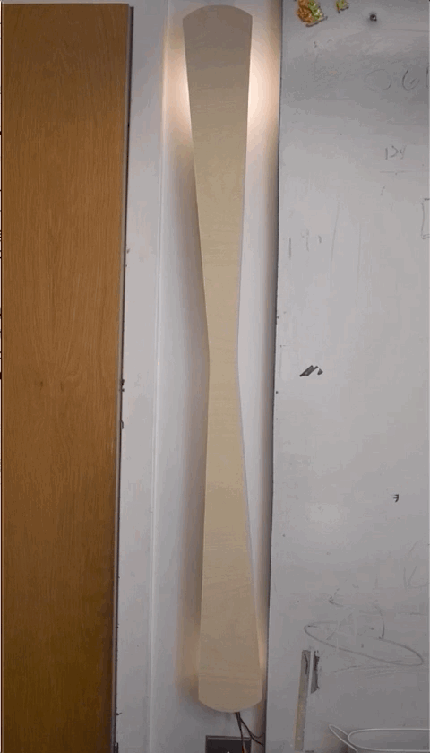 Photo of long thin wooden wall sconce with light running down the back of the sconce
